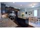 Stylish kitchen featuring dark cabinets, stainless steel appliances, granite countertops, and a cozy dining area at 1254 Salters St, Burlington, NC 27215