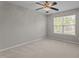 Bright bedroom featuring neutral carpet, a ceiling fan, and a large window at 1313 Legacy Greene Ave, Wake Forest, NC 27587