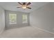 Bright bedroom featuring neutral carpet, a ceiling fan, and two large windows at 1313 Legacy Greene Ave, Wake Forest, NC 27587