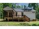 Back exterior showcasing a wooden deck, screened-in porch, and a well-maintained lawn at 136 Hatchet Cv, Louisburg, NC 27549