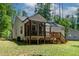 Back exterior view with a cozy screened-in porch and wooden deck overlooking the yard at 136 Hatchet Cv, Louisburg, NC 27549