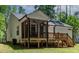 Back porch area with a screened-in porch, wooden deck, and serene backyard at 136 Hatchet Cv, Louisburg, NC 27549