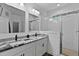 This bright bathroom features double sinks and a glass-enclosed shower with modern fixtures at 136 Hatchet Cv, Louisburg, NC 27549