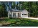 Beautiful white home with a manicured lawn, front porch, and convenient two-car garage at 136 Hatchet Cv, Louisburg, NC 27549