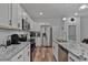 Close-up of the white kitchen featuring stainless steel appliances and granite countertops at 136 Hatchet Cv, Louisburg, NC 27549
