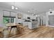Bright open-concept kitchen with white cabinets, stainless steel appliances, and wood flooring at 136 Hatchet Cv, Louisburg, NC 27549