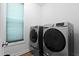 This well-lit laundry room features modern, front-loading machines and sleek designs at 136 Hatchet Cv, Louisburg, NC 27549