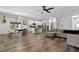 Open-concept living room with stainless steel appliances and wood flooring, bathed in natural light from a nearby window at 136 Hatchet Cv, Louisburg, NC 27549