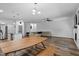 Bright open-concept living room with modern table, stainless steel appliances, and wood flooring at 136 Hatchet Cv, Louisburg, NC 27549