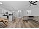 Bright open-concept living room with white walls, stainless steel appliances, and wood flooring at 136 Hatchet Cv, Louisburg, NC 27549