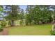 Sprawling backyard showcasing lush greenery, mature trees, and view of the manicured golf course at 14 Duck Bill Trl, Pittsboro, NC 27312