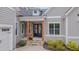 Charming covered front porch with stone stairs, timber posts and updated black entry door at 14 Duck Bill Trl, Pittsboro, NC 27312