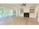 Bright living room with fireplace, built-ins, hardwood floors, and access to screened porch at 14 Duck Bill Trl, Pittsboro, NC 27312