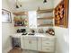 Charming wet bar with floating shelves, a beverage fridge, and ample storage at 14 Duck Bill Trl, Pittsboro, NC 27312