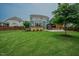 A spacious backyard featuring a deck, a covered patio, lush green lawn, and mature trees for shade and privacy at 2020 Cotton Barn Ct, Wendell, NC 27591
