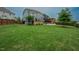 Expansive backyard featuring a well-maintained lawn, a wooden fence, a covered patio and manicured landscaping at 2020 Cotton Barn Ct, Wendell, NC 27591