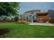 A serene backyard features a deck, a covered patio, lush green lawn, and mature trees for shade and privacy at 2020 Cotton Barn Ct, Wendell, NC 27591