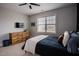Bright bedroom with soft natural light from the windows, ceiling fan, and wooden dresser at 2020 Cotton Barn Ct, Wendell, NC 27591