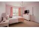 Charming bedroom featuring soft pink walls, white furniture, and a beautiful chandelier at 2020 Cotton Barn Ct, Wendell, NC 27591