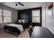 Modern bedroom with black accent wall, ceiling fan, and a cozy bed near bright windows at 2020 Cotton Barn Ct, Wendell, NC 27591