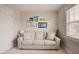 Cozy room with neutral walls and carpet, featuring a comfortable sofa and artwork on the wall at 2020 Cotton Barn Ct, Wendell, NC 27591