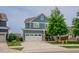 Charming blue home with a two-car garage, manicured lawn, and welcoming front porch at 2020 Cotton Barn Ct, Wendell, NC 27591