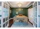 Elegant home office with rich green walls, a stylish chandelier, and French door entry at 2020 Cotton Barn Ct, Wendell, NC 27591