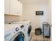 This laundry room features a washer, dryer, utility sink, and tile flooring at 2020 Cotton Barn Ct, Wendell, NC 27591