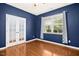 Bedroom with wooden floors, white trim, blue accent wall, and natural light at 213 Florence Dr, Clayton, NC 27527