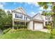 Two-story home featuring brick accents, white siding, manicured landscaping, and an attached two-car garage at 213 Florence Dr, Clayton, NC 27527