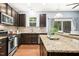 Modern kitchen with stainless steel appliances, dark wood cabinets, granite countertops, and a center island with seating at 213 Florence Dr, Clayton, NC 27527
