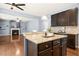 Modern kitchen with stainless steel appliances, dark wood cabinets, granite countertops, and open to living room at 213 Florence Dr, Clayton, NC 27527