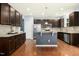 Modern kitchen featuring stainless steel appliances, dark wood cabinets, granite countertops, and a center island at 213 Florence Dr, Clayton, NC 27527