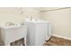 Bright laundry room featuring modern white washer and dryer, utility sink and ample shelving for convenient storage at 213 Florence Dr, Clayton, NC 27527