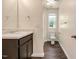 Cozy bathroom features dark wood cabinets, a large mirror and a toilet next to a window at 221 Hallow Oak St, Spring Lake, NC 28390