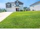 Spacious front yard with lush green grass, complemented by the house and driveway, offers curb appeal at 221 Hallow Oak St, Spring Lake, NC 28390