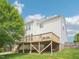 Backyard showcasing a wooden deck, ample green space, and the exterior of the house at 2317 Colony Woods Dr, Apex, NC 27523