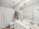 Bright bathroom featuring a double sink vanity, large mirror, and a shower with a white curtain at 2317 Colony Woods Dr, Apex, NC 27523