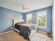 Comfortable bedroom featuring blue walls, ceiling fan, two windows, and white bed frame at 2317 Colony Woods Dr, Apex, NC 27523
