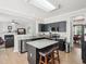 Modern kitchen with black cabinets, stainless steel appliances, granite counters, and an island with seating at 2317 Colony Woods Dr, Apex, NC 27523