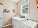 Cozy laundry room featuring a washer, dryer, utility sink, and window for natural light at 2317 Colony Woods Dr, Apex, NC 27523
