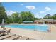 Community pool with various lounge chairs, tables, and a covered picnic area nearby at 2317 Colony Woods Dr, Apex, NC 27523