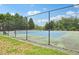 View of a fenced tennis court with a blue and green playing surface at 2317 Colony Woods Dr, Apex, NC 27523