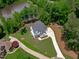Aerial view of the home highlighting its landscaping, circular driveway and adjacency to beautiful pond at 248 Ashford Dr, Pittsboro, NC 27312