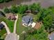 A stunning aerial view of a new lakefront home with a long driveway and mature trees at 248 Ashford Dr, Pittsboro, NC 27312