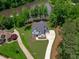 Aerial view of the home showcasing its dark roof, lush surroundings, and proximity to a picturesque pond at 248 Ashford Dr, Pittsboro, NC 27312
