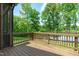 Back deck with wood railing overlooking the backyard, lake and mature trees at 248 Ashford Dr, Pittsboro, NC 27312