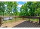 Back deck with wood railing overlooking the backyard, lake and mature trees at 248 Ashford Dr, Pittsboro, NC 27312