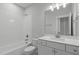 Modern bathroom with white subway tile, white vanity, and a combined tub and shower at 248 Ashford Dr, Pittsboro, NC 27312