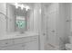 Bathroom features white single sink vanity with quartz countertop and a door to the shower and toilet at 248 Ashford Dr, Pittsboro, NC 27312